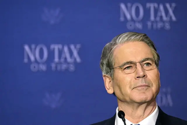 Scott Bessent in glasses against a backdrop the reads 'no tax on tips'