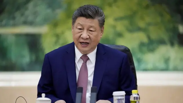 Xi Jinping sat in front of a green painting