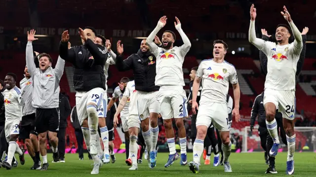 Players of Leeds United celebrate towards their fans after the team's victory in the Premier League match between Manchester United and Leeds United at Old Trafford