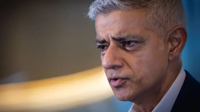 Close up of Mayor of London Sadiq Khan looking to the left of the image and wearing a suit