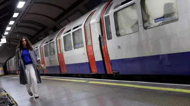 A woman walks along an empty platform during a series of 24-hour tube strikes represented by the RMT union in dispute with TFL over working patterns