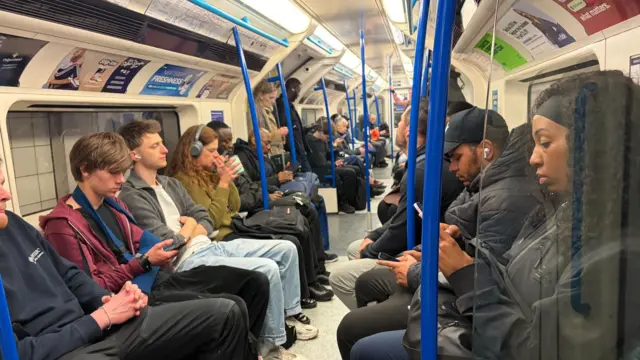 Interior shot of a busy, but not crammed, Vicoria line train