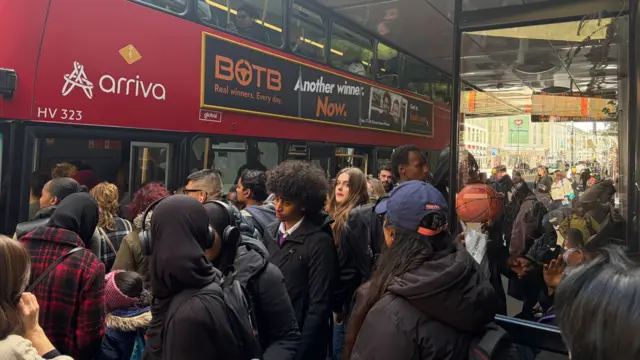 A crowd of people getting on to a bus at Finsbury Park station