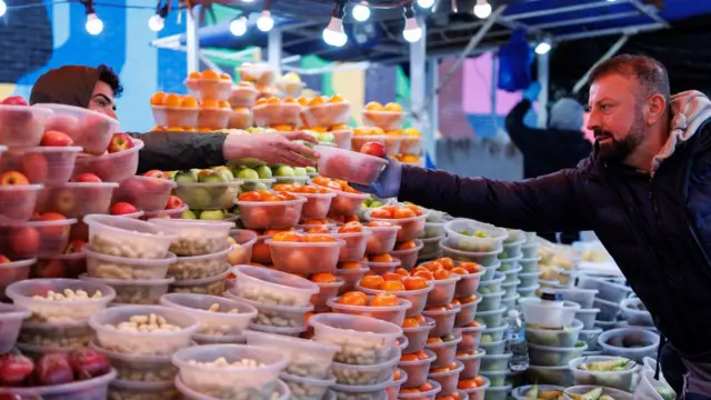 Customers shop for fresh produce at Ridley Road Market in Dalston, east London