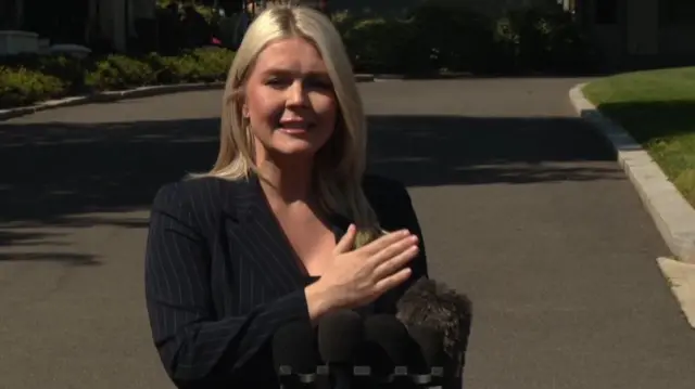 Karoline Leavitt outside the White House stands in front of microphones