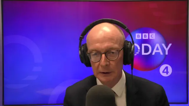 Pat McFadden speaking into microphone with headphones on in Today studio