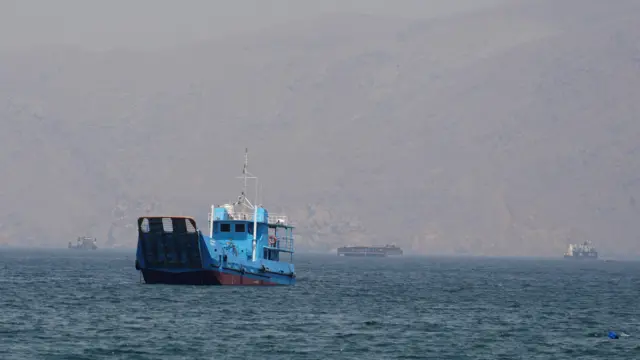 A blue shipping vessel sits in water