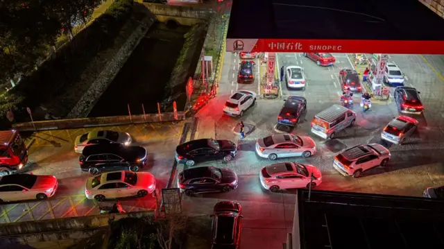 Dozens of cars queue at a Sinopec station in China at night
