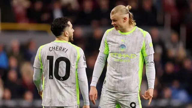 : Erling Haaland of Manchester City speaks to teammate Rayan Cherki