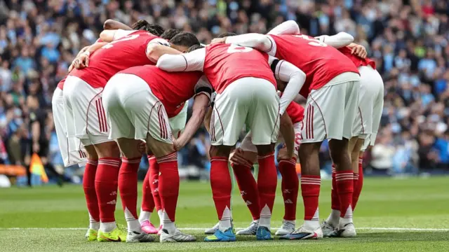 Arsenal players gather in a huddle