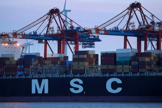 A shipping container with MSC on the side has containers onboard