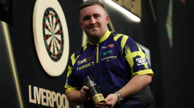 Luke Littler with the Premier League night 12 trophy