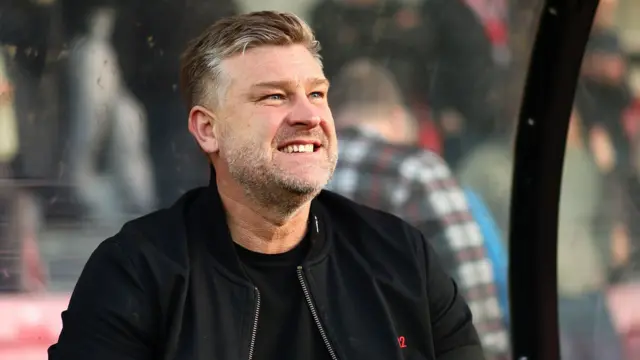 Karl Robinson smiles on the sideline