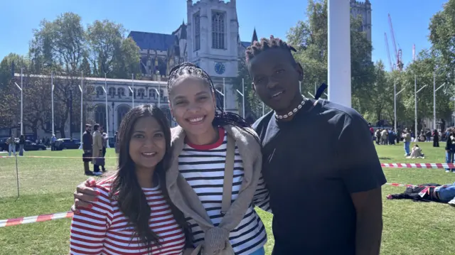 Camille and her two friends Jessica and Arnold stand in Parliament Square outside Westminster Abbey