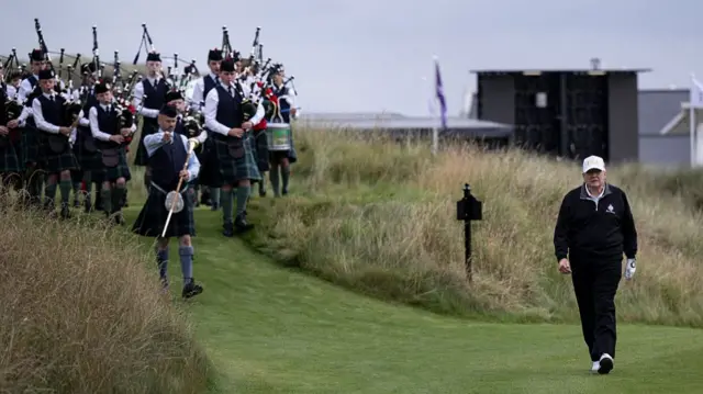 Donald Trump is followed by bagpipers as he walks on his Scottish golf course in Aberdeenshire