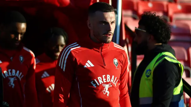 Salford City's Ryan Graydon, wearing a red Adidas training top with a Salford badge on, in the warm-up before kick-off against Bromley