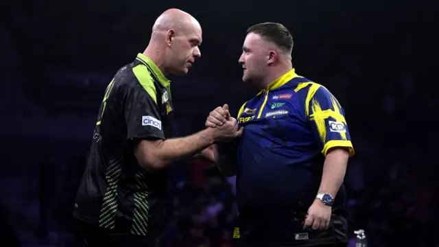 Michael van Gerwen shakes hands with Luke Littler