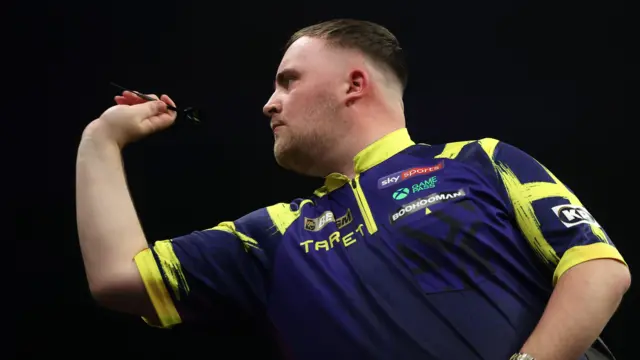 Luke Littler throws a dart