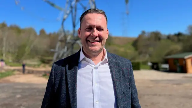 Scottish Tory leader Russell Findlay stands before a "monster pylon" in Auchenblae
