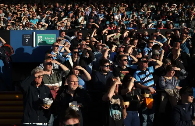 Fans shielding their eyes
