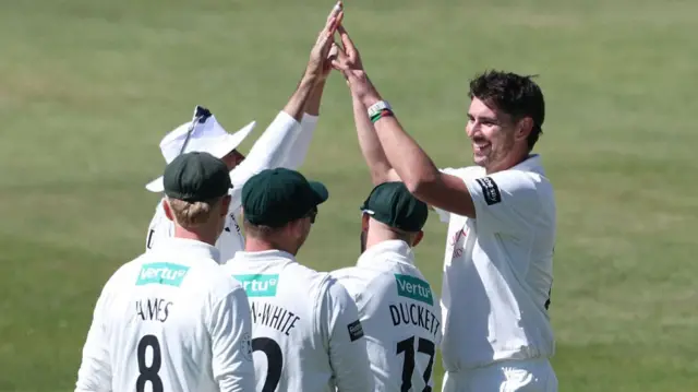 Bowler Josh Tongue of Nottinghamshire celebrates taking a wicket with four of his team-mates