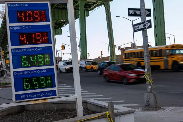 A digital display outside a petrol station next to a busy New York road displays prices above $4 per gallon for regular gasoline