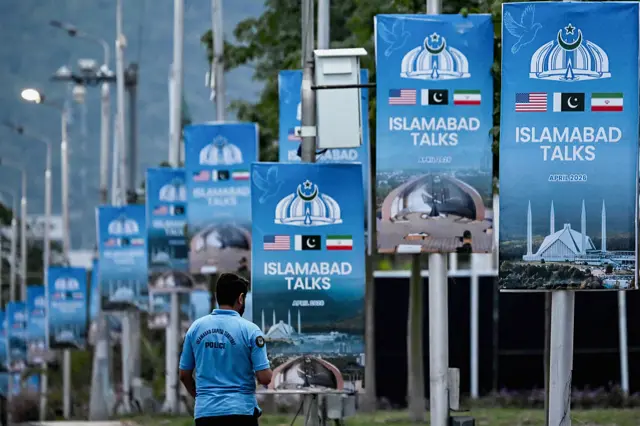 Blue posters line the side of a street in Islamabad highlighting Pakistan's mediation of Iran-US peace talks