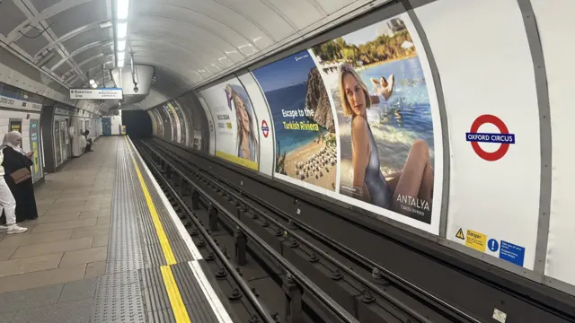 Quiet Oxford Circus platform with few people waiting for a Tube