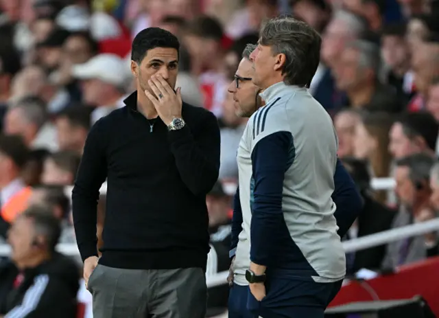 Mikel Arteta talks to his coaches