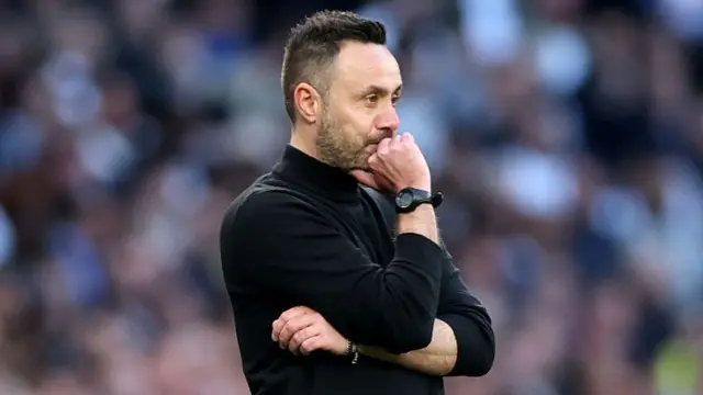 Roberto De Zerbi puts his knuckles to his mouth and looks nervous on the Tottenham sideline