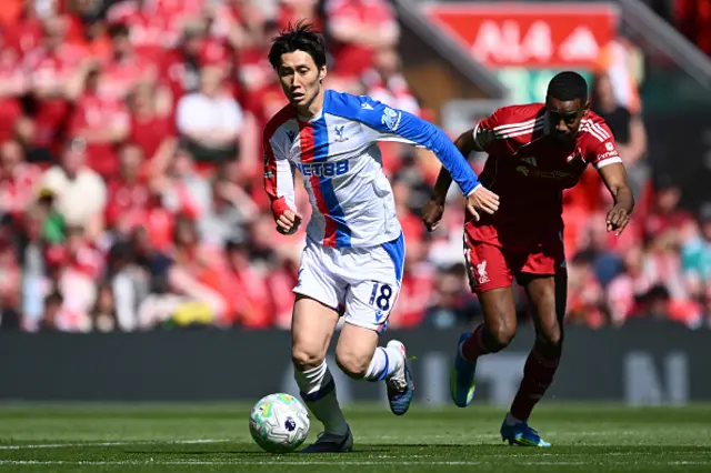Daichi Kamada of Crystal Palace runs with the ball past Alexander Isak