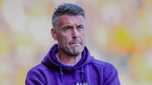 Rob Edwards looks grump and folds his arms on the Wolves sideline