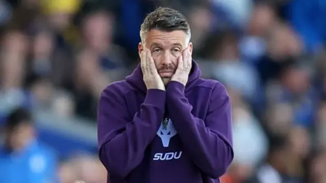 Rob Edward puts his hands to his face in disappointment on the Wolves sideline