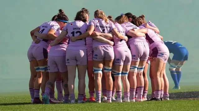 Scotland huddle together for a chat in bright purple kits