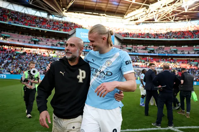 Pep Guardiola, Manager of Manchester City, celebrates with Erling Haaland