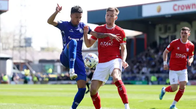 Kyron Gordon of Rochdale is challenged by Mark Kitching of York City