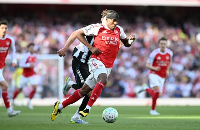 Noni Madueke of Arsenal runs with the ball under pressure from Sven Botman