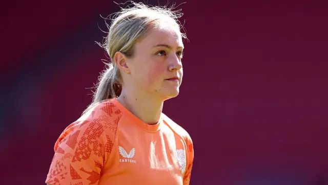 Millie David in a bright orange England Rugby training top