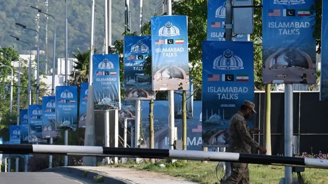 An army soldier walks past posters highlighting Pakistan's mediation of IranUS peace talks near the Serena Hotel at the Red Zone area in Islamabad on April 22, 2026.