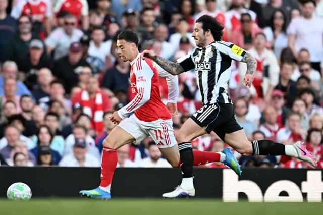 Gabriel Martinelli of Arsenal runs with the ball under pressure from Sandro Tonali