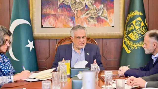 Dar sits at a table between two people