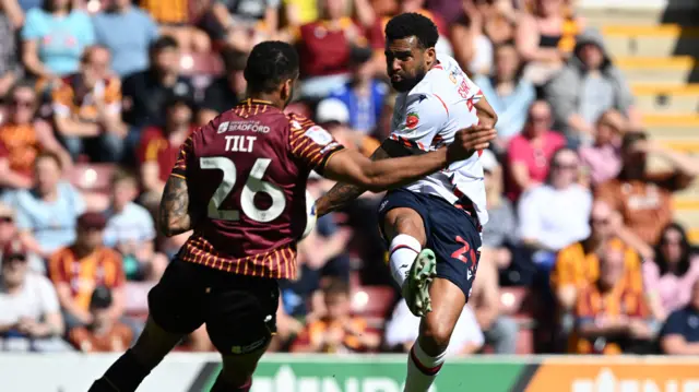 Cyrus Christie of Bolton Wanderers shoots at goal blocked by Curtis Tilt of Bradford City