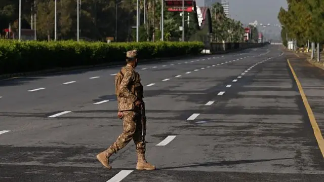 A soldier mans a deserted street - closed in preparation for possible talks - in Pakistan's capital, Islamabad
