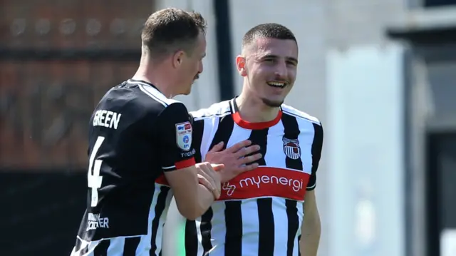 Maldini Kacurri of Grimsby Town (facing) celebrates scoring their second goal against Swindon from a free kick.