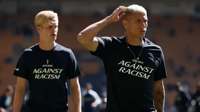 Lucas Bervall and Richarlison wearing Tottenham's black and white anti-racism message warm-up T shirt