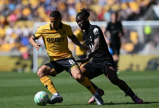 Joao Gomes of Wolverhampton Wanderers is challenged by Yves Bissouma of Tottenham Hotspur
