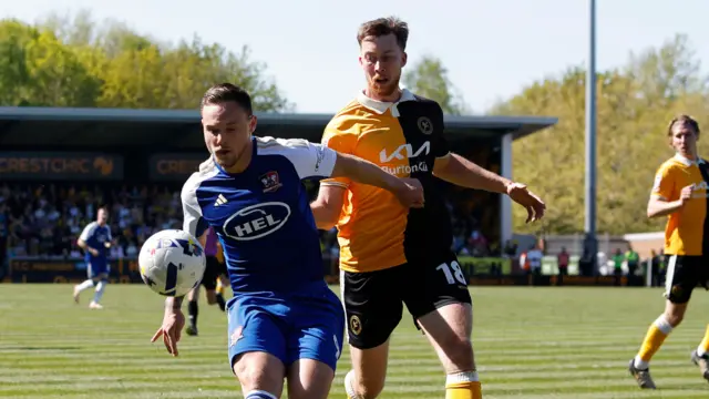 Jayden Wareham of Exeter City feels pressure from Jasper Moon of Burton Albion