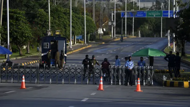 Pakistani security officials stand guard at a checkpoint amid a high-level security lockdown ahead of anticipated talks in Islamabad