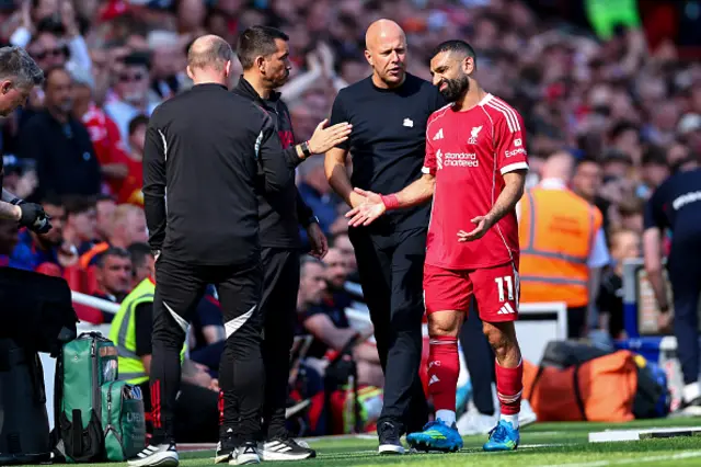 Arne Slot manager / head coach of Liverpool speaks with Mohamed Salah of Liverpool as he goes off injured