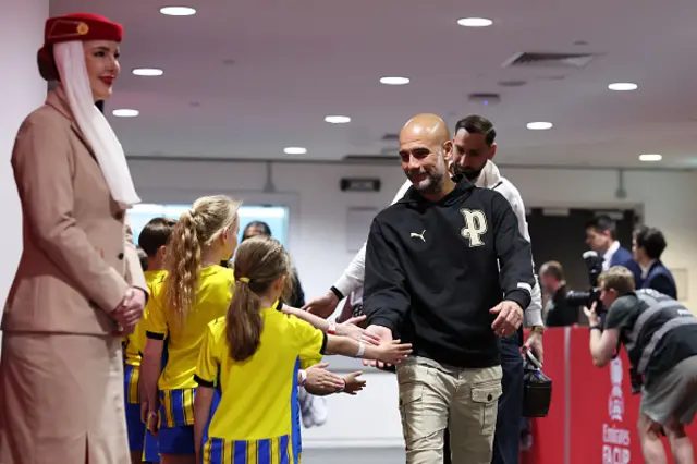 Pep Guardiola, Manager of Manchester City, high fives mascots
